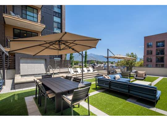 A patio with a table and chairs under an umbrella.