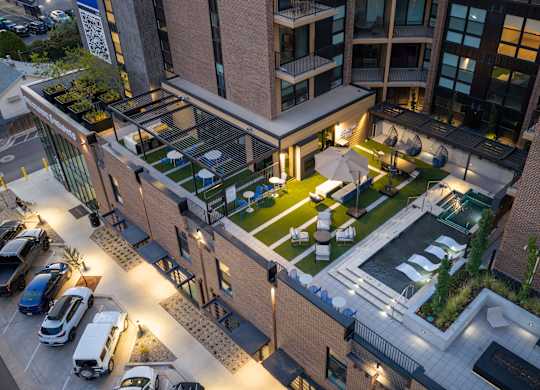 A modern building with a green roof and a parking lot in front.