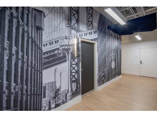 A black and white photo of a bridge is on the wall of a room.