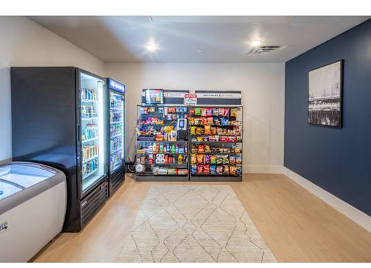 A room with a vending machine and a fridge.