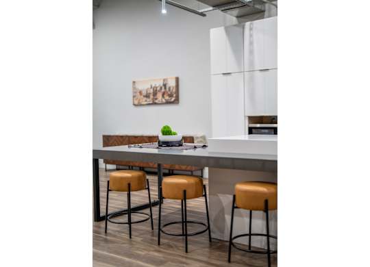 A kitchen with a bar counter and two stools.