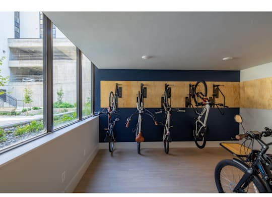 A bike room with bikes on the wall and a window.