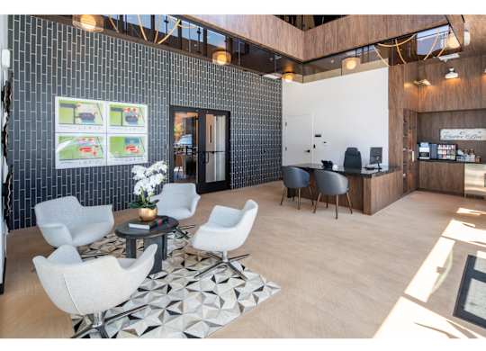 A modern office space with a black tiled wall and a white sofa.