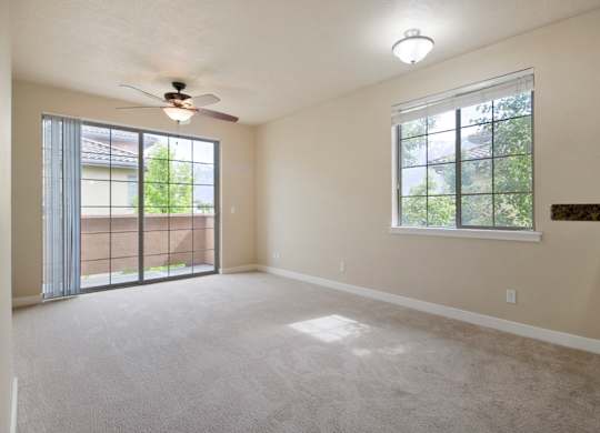 A room with a ceiling fan and a window with a view of trees at Siena Villas Apartments, Orem, Utah