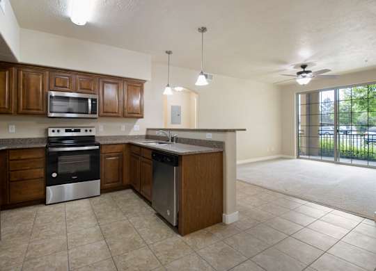 A kitchen with brown cabinets and a black refrigerator. at Siena Villas Apartments, Apartments, Orem, UT