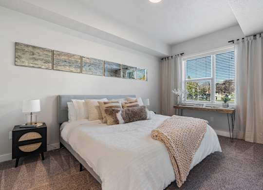 a bedroom with a large bed and a window at The Flats at Riverwoods, Provo, UT, 84604