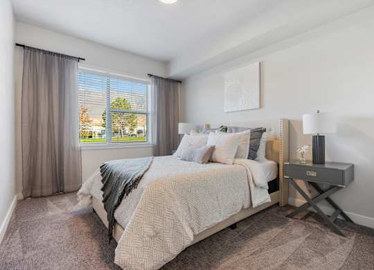 a bedroom with a bed and a window at The Flats at Riverwoods, Provo, UT, 84604