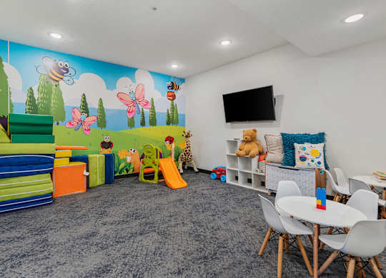 a play room with chairs and toys and a wall mural at The Flats at Riverwoods, Provo, UT