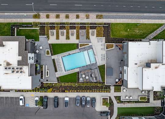 an aerial view of a mansion with a large swimming pool in the center of it at The Flats at Riverwoods, Provo, Utah