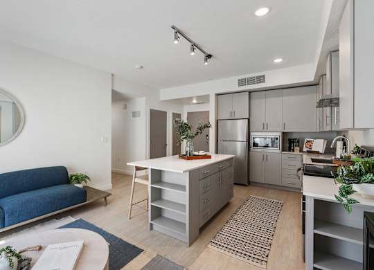 a living area with a kitchen and a blue couch at Paperbox Lofts, Salt Lake City, Utah