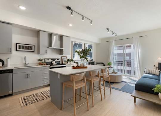 an open kitchen and living room with a large island and a dining table at Paperbox Lofts, Salt Lake City
