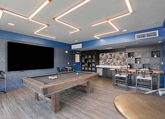 a game room with a pool table and a tv at Paperbox Lofts, Utah, 84101