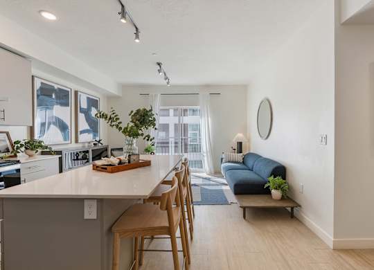 a living area with a kitchen and a living room with a couch at Paperbox Lofts, Salt Lake City, UT, 84101