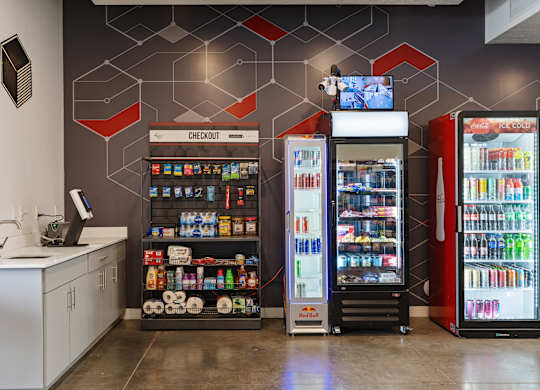 A modern convenience store with a variety of drinks and a self-service area.