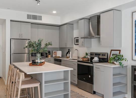 a kitchen with white cabinets and black appliances and a white counter top at Paperbox Lofts, Salt Lake City, UT, 84101