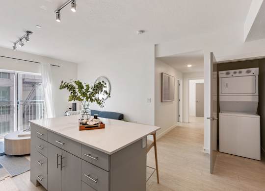 a kitchen with an island and a living room with a refrigerator at Paperbox Lofts, Salt Lake City, UT