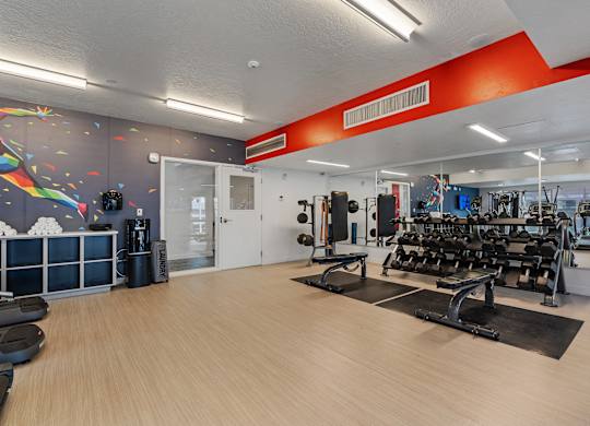 a gym with cardio machines and weights on a wooden floor at Paperbox Lofts, Salt Lake City, UT, 84101