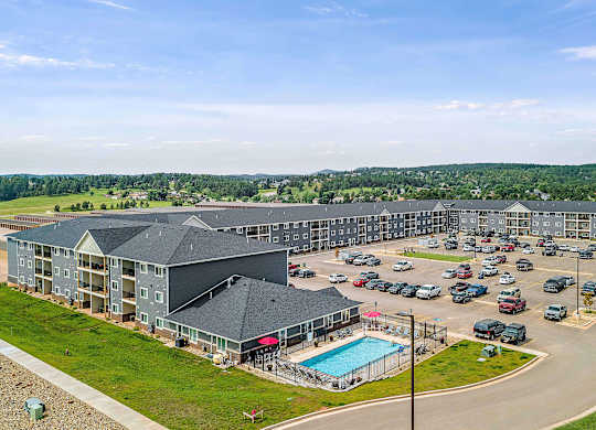 a large apartment complex with a swimming pool and parking lotv
