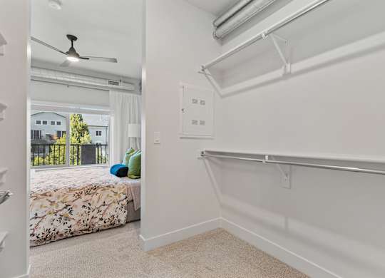 an empty bedroom with a bed and a closet with a sliding glass door at The Revival, Utah, 84101