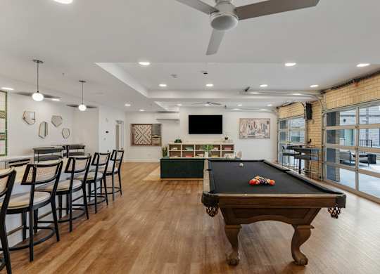 a game room with a pool table and a bar with chairs at The Revival, Salt Lake City, Utah