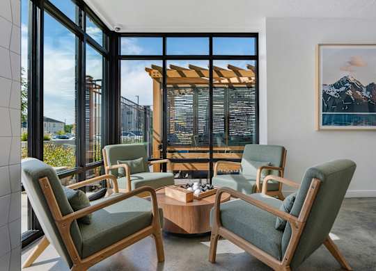 a living room with chairs and a coffee table and a view of a mountain at The Flats at Riverwoods, Provo