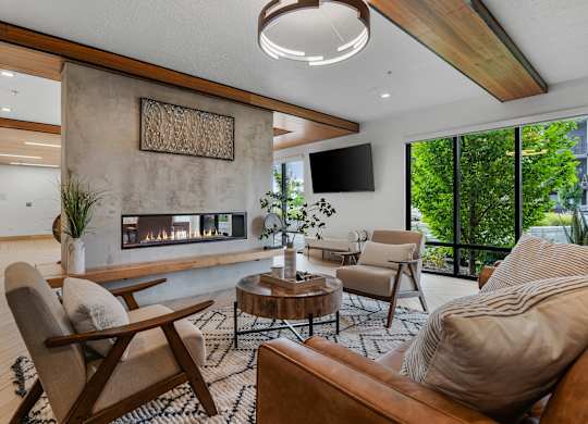 a living room with couches and chairs and a fireplace at The Flats at Riverwoods, Provo