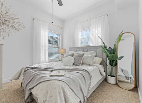 a white bedroom with a bed and a mirrorat The View on 20th, Ogden