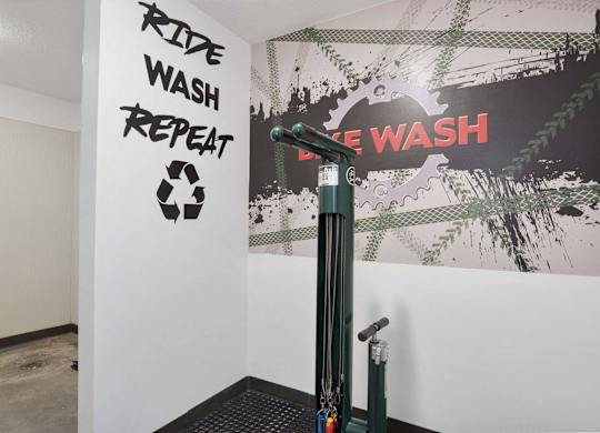 a room with a washing machine and a poster on the wall at The Flats at Riverwoods, Provo, Utah