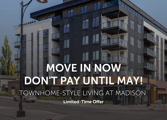 A modern apartment building with a sign advertising a move-in offer.