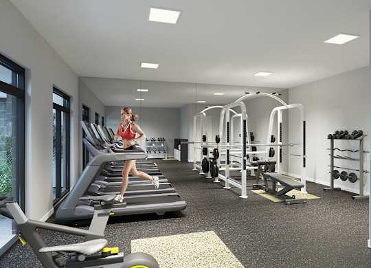 A woman is running on a treadmill in a well-equipped gym.