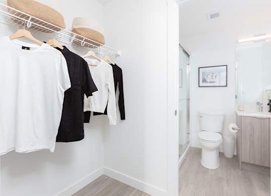 Clothes hanging on a rack in a white room.