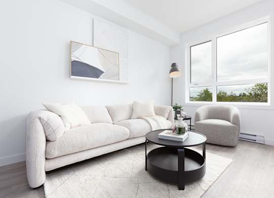 A white couch sits in a living room with a coffee table in front of it.