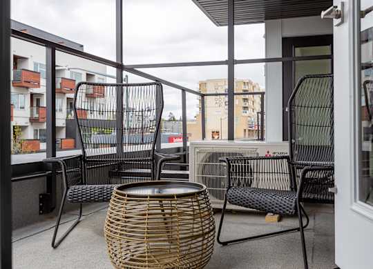 A balcony with a table and chairs.