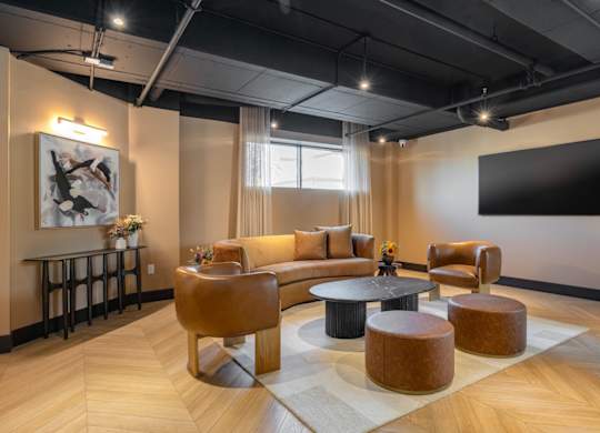 A modern living room with a large couch, a coffee table, and a TV mounted on the wall.
