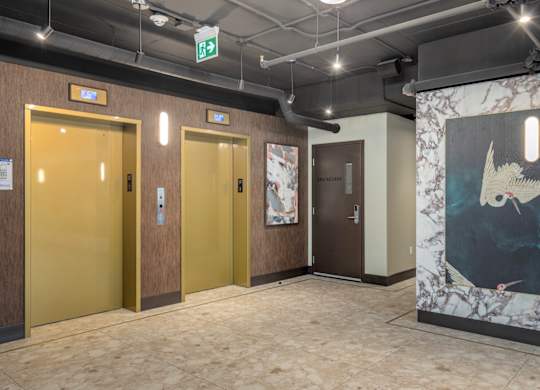 A hallway with three doors and a painting on the wall.