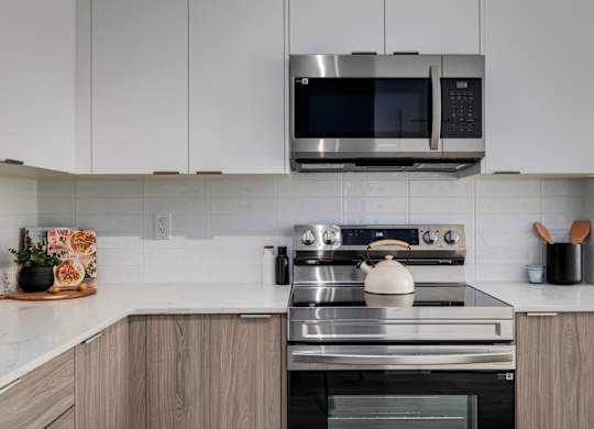 A modern kitchen with a stainless steel oven and microwave above it.