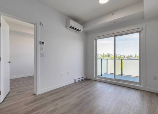 A room with a sliding glass door leading to a balcony.