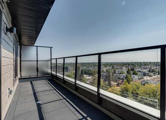 A balcony with a metal railing overlooks a cityscape.