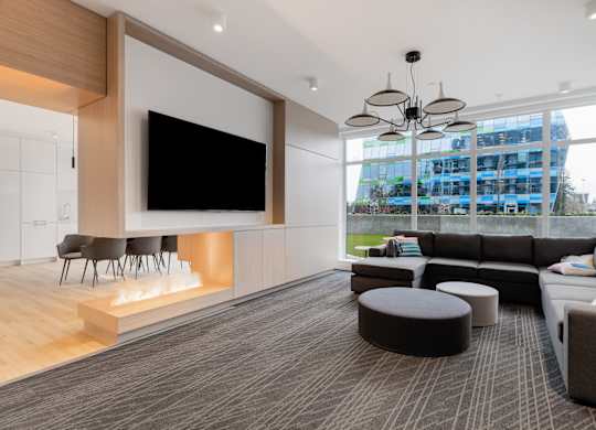 A modern living room with a large flat screen TV mounted on the wall.