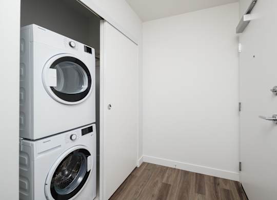 A white washing machine and dryer in a small laundry room.
