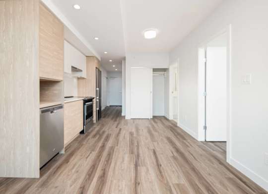 A kitchen with wooden floors and white walls.