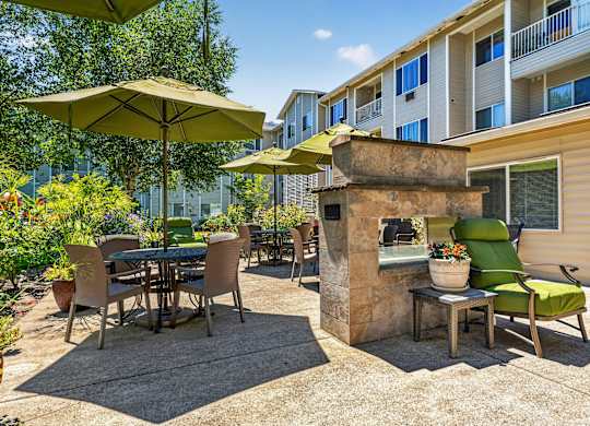 A patio with a table and chairs and a stone fireplace.