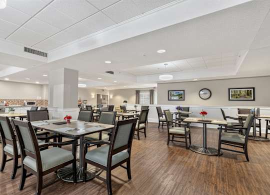 A restaurant with wooden floors and tables with chairs.