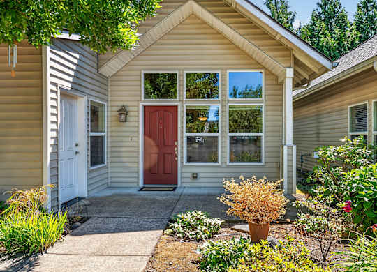 A house with a red door and a small front yard.