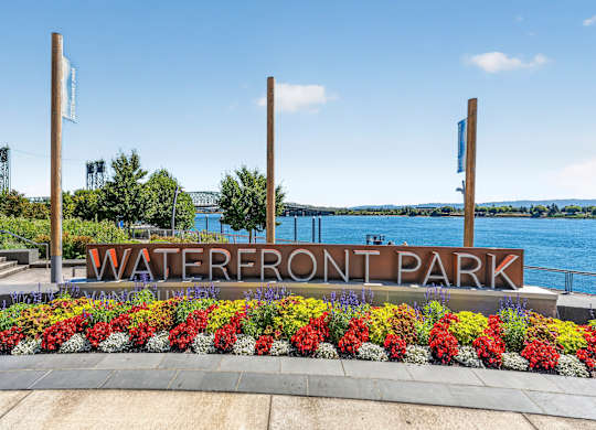 A sign that says Waterfront Park in front of a body of water.