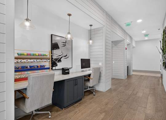 A modern office with a white desk and a grey chair in the business center