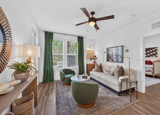 A living room with a white couch, green armchair, and a rug.