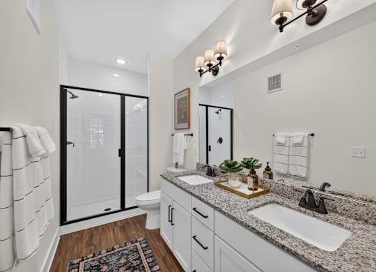A bathroom with a sink, mirror, and a glass shower door.