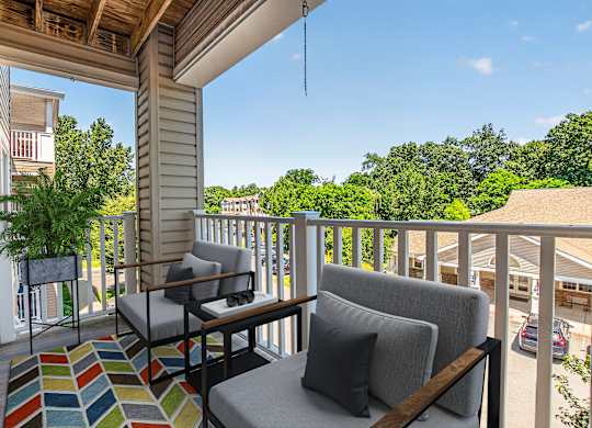 A balcony with a couch, chair, and table.