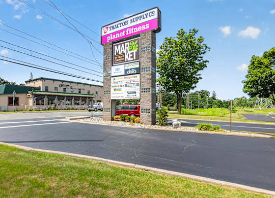 A sign for a tractor supply store is in front of a building.